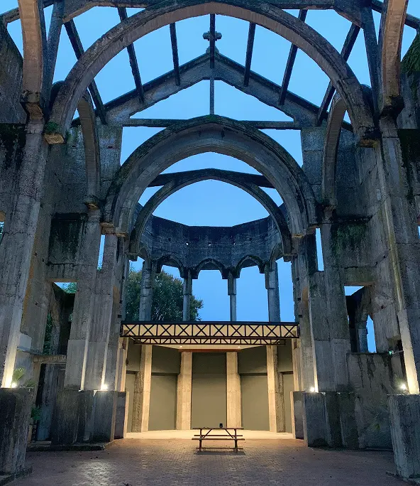 Intérieur de L’Église Inachevée à Montauban avec podium lumineux et toiture inachevée